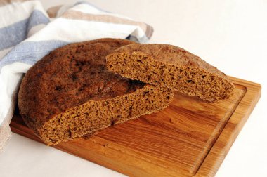 Tahta üzerinde taze ev yapımı malt çavdar ekmeği, keten kumaş. Beyaz arkaplanda