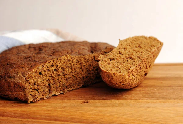 Tahta üzerinde taze ev yapımı malt çavdar ekmeği, keten kumaş. Beyaz arkaplanda