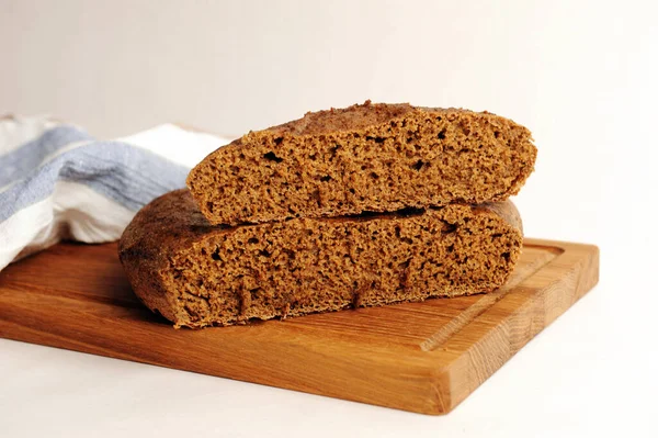 Tahta üzerinde taze ev yapımı malt çavdar ekmeği, keten kumaş. Beyaz arkaplanda