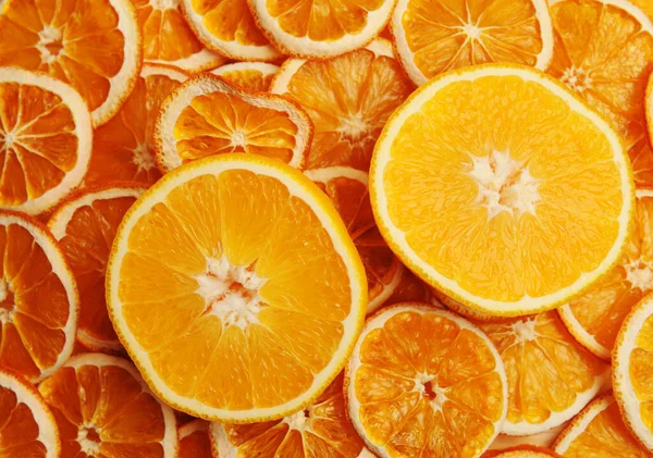 Fresh orange cut in half on dried orange slices background, top view