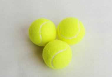 Beyaz arka planda üç büyük tenis topu, üst manzara. Spor konsepti