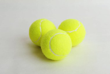Beyaz arka planda üç büyük tenis topu, üst manzara. Spor konsepti