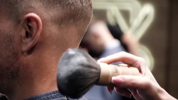 Peluquería utiliza cepillo para deslizar el pelo cortado del cuello del hombre — Vídeos de Stock