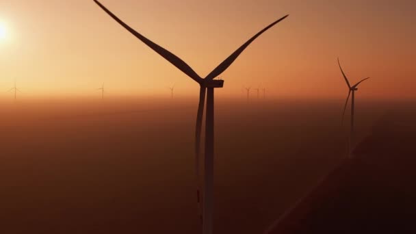 Mulini a vento ruotano al tramonto nella nebbia sulla stazione offshore — Video Stock