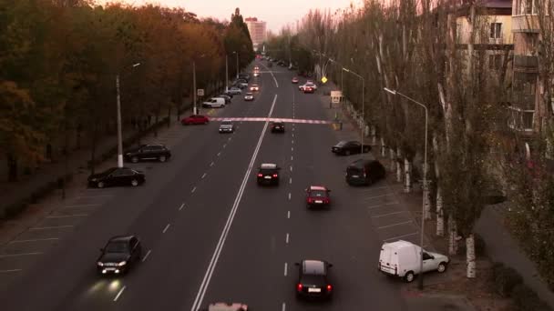 자동차는 해질 녘에 표시가 되어 있는 길고 넓은 도시 도로를 달리고 있다 — 비디오