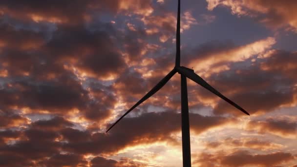 Wind turbine produces clean energy against bright cloudy sky — Stockvideo
