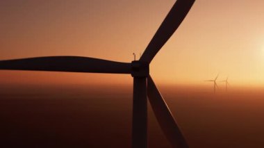 Wind turbine with powerful propeller rotates at sunset