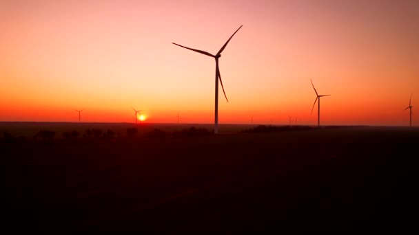 Wind turbines generate electricity at station against sunset — Stockvideo