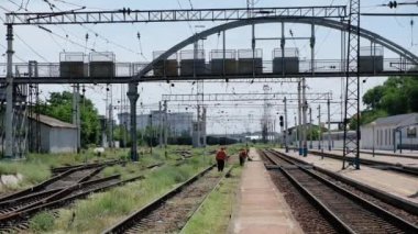 Demiryolu işçileri tren yolu boyunca çim biçer..