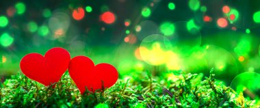 Sevgililer Günü arka planında iki kırmızı kalp ve çok renkli bir bokeh. Aşk konsepti. Neşeli arkaplan.