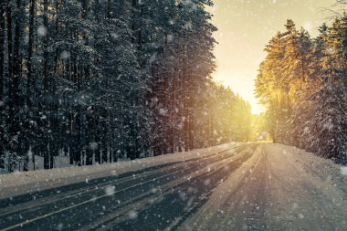 beautiful winter background with a snow-covered forest road