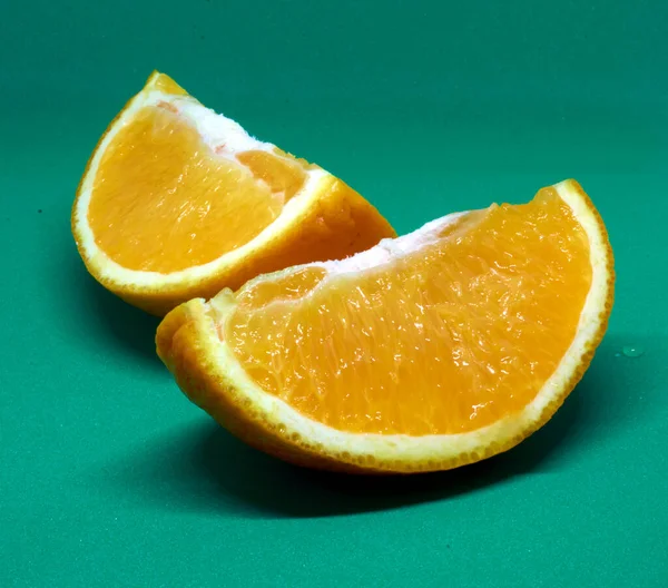 绿色背景上新鲜切碎的橙子 — 图库照片