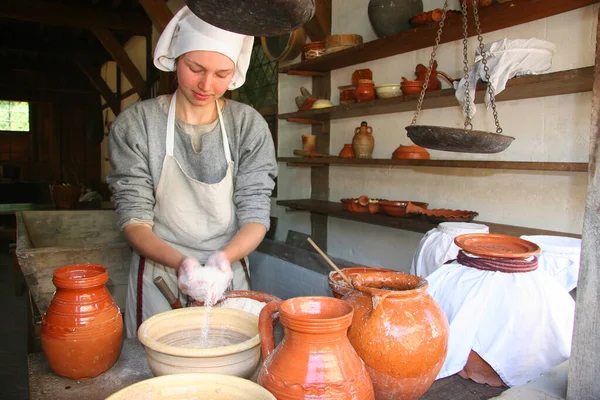 Eski moda kostümlü kadın yemek yapıyor.