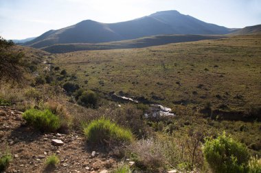 Gün batımında panoramik dağ manzarasında aşınmış kayalar önlükle kaplanır. 