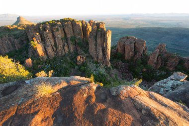 Gün batımında panoramik dağ manzarasında aşınmış kayalar önlükle kaplanır. 