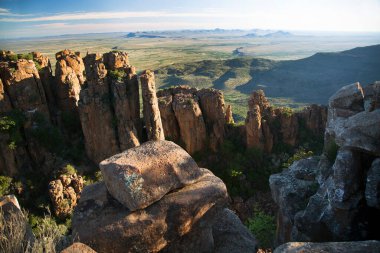 Gün batımında panoramik dağ manzarasında aşınmış kayalar önlükle kaplanır. 