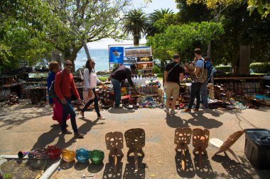 Tourists at souvenir street market with different types of merchandise 