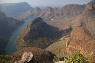 Nehirle aşındırılmış dağ manzarası vadi tabanını keserek bir kanyon oluşturuyor. 