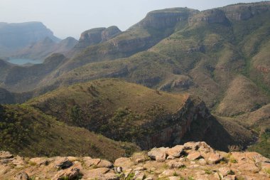 Nehirle aşındırılmış dağ manzarası vadi tabanını keserek bir kanyon oluşturuyor. 
