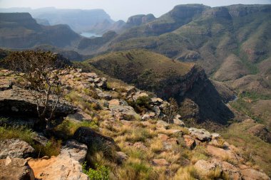 Nehirle aşındırılmış dağ manzarası vadi tabanını keserek bir kanyon oluşturuyor. 