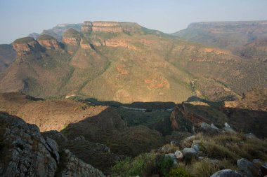Nehirle aşındırılmış dağ manzarası vadi tabanını keserek bir kanyon oluşturuyor. 