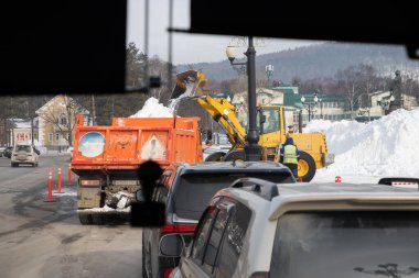 Temizlik traktör (kar temizleme makinesi) yükleme bir damperli kamyon kar yığını kar. İzole et. Kar pulluk açık havada sokak şehir temizlik blizzard veya kar yağışı sonra.