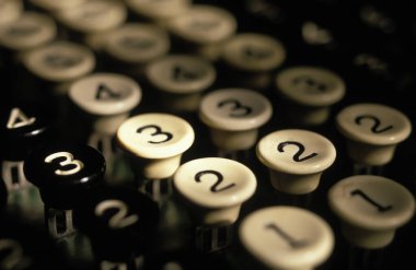 Eski bir ekleme makinesinin ve numara anahtarlarının yakın plan görüntüsü.