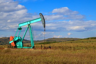 Alberta, Kanada 'da bir petrol pompacısı. Petrol pompası, bir petrol kuyusunda karşılıklı piston pompası için zemin sürücüsüdür.. 