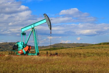 Alberta, Kanada 'da bir petrol pompacısı. Petrol pompası, bir petrol kuyusunda karşılıklı piston pompası için zemin sürücüsüdür.. 