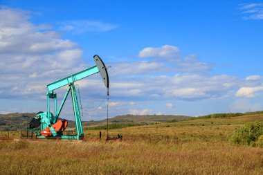 Alberta, Kanada 'da bir petrol pompacısı. Petrol pompası, bir petrol kuyusunda karşılıklı piston pompası için zemin sürücüsüdür.. 