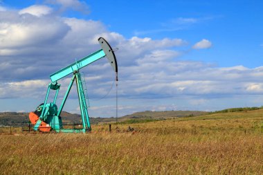 Alberta, Kanada 'da bir petrol pompacısı. Petrol pompası, bir petrol kuyusunda karşılıklı piston pompası için zemin sürücüsüdür.. 
