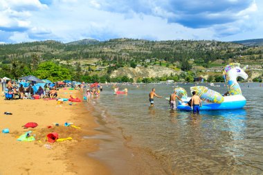 Penticton, British Columbia, Kanada - 1 Temmuz 2022: Kanada Günü ve yaz eğlencesi sırasında Skaha Gölü sahilinde turist, Penticton, British Columbia, Kanada 'daki Okanagan Vadisi' nde.