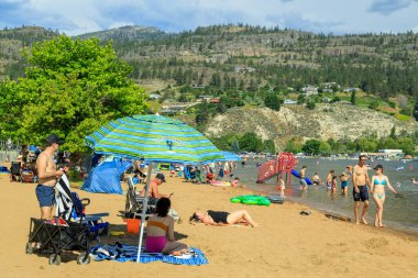 Penticton, British Columbia, Kanada - 1 Temmuz 2022: Kanada Günü ve yaz eğlencesi sırasında Skaha Gölü sahilinde turist, Penticton, British Columbia, Kanada 'daki Okanagan Vadisi' nde.
