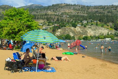 Penticton, British Columbia, Kanada - 1 Temmuz 2022: Kanada Günü ve yaz eğlencesi sırasında Skaha Gölü sahilinde turist, Penticton, British Columbia, Kanada 'daki Okanagan Vadisi' nde.