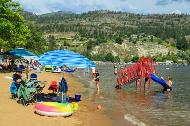 Penticton, British Columbia, Kanada - 1 Temmuz 2022: Kanada Günü ve yaz eğlencesi sırasında Skaha Gölü sahilinde turist, Penticton, British Columbia, Kanada 'daki Okanagan Vadisi' nde.