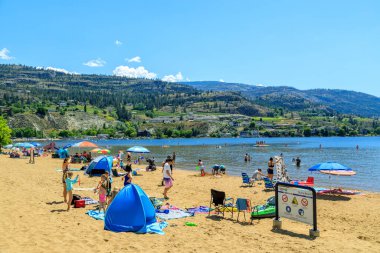 Penticton, British Columbia, Kanada - 30 Haziran 2022: Kanada Günü ve yaz eğlencesi sırasında Skaha Gölü sahilinde turist, Penticton, British Columbia, Kanada 'daki Okanagan Vadisi' nde yer alır..