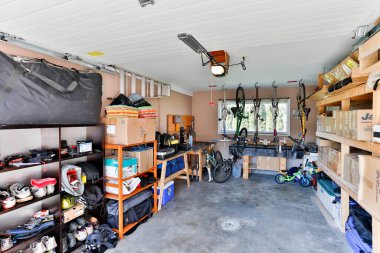 Squamish, British Columbia, Canada - April 2, 2016: An organized indoor house garage storage filled with personal stuff and junk stacked on shelves.