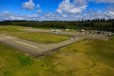 Masset, British Columbia, Canada - June 3, 2022: An aerial view of the runway tarmac of the remote Masset airport located in Haida Gwaii, British Columbia, Canada.