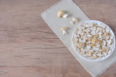 Taze mantarlar Calocybe gambosa yuvarlak bir tabakta yatar. Metnin için bir yer.