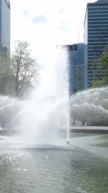 İlkbaharda şehirde bir çeşme. Dikey video.