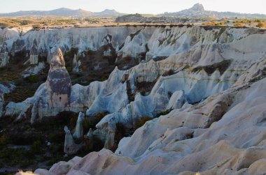 Kapadokya 'nın tipik jeolojik oluşumlarının yakın plan manzarası. İnanılmaz şekilli kumtaşı kayaları. Ünlü turistik yer ve romantik seyahat yeri. Güzel sonbahar güneşli öğleden sonra.