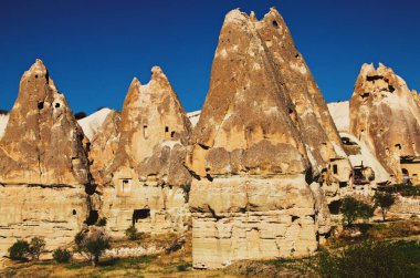 Güneşli bir sonbahar sabahı Goreme 'deki antik mağara evlerinin yakın görüntüsü. Kayaların içindeki yeraltı şehri. Dağların muhteşem manzaraları ve Cappadocia 'nın muhteşem kaya oluşumları..