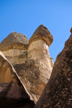 Goreme yakınlarındaki Pasaba Vadisi 'ndeki ünlü Peri Bacaları' nın ya da çok başlı taş mantarların yakın çekim görüntüsü. Mavi gökyüzü arka planı. Türkiye 'de popüler seyahat noktası. UNESCO Dünya Mirası Alanı.