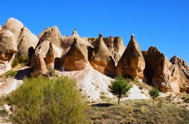 Güneşli bir sonbahar sabahı Goreme 'deki antik mağara evlerinin yakın görüntüsü. Kayaların içindeki yeraltı şehri. Dağların muhteşem manzaraları ve Cappadocia 'nın muhteşem kaya oluşumları..