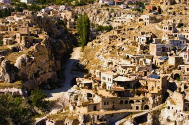 Antik Ortahisar mağara şehrinin muhteşem panoramik manzarası. Mavi gökyüzü arka planı. Türkiye 'de popüler seyahat noktası. UNESCO Dünya Mirası Alanı. Sonbahar güneşli gün manzarası.