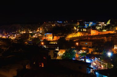 Ünlü mağara şehri Goreme 'in gece aydınlığı manzarası. Aydınlanmış binaların manzarası. Türkiye 'de popüler seyahat noktası. UNESCO Dünya Mirası Alanı.