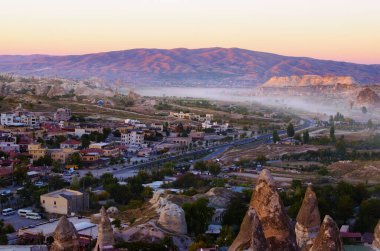 Kapadokya 'daki antik Goreme' in günbatımı manzarası. Kum taşı şeklindeki kayalıklardaki inanılmaz mağara evleri. Türkiye 'de popüler seyahat noktası. UNESCO Dünya Mirası Alanı.