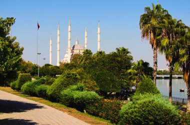 Sabancı Merkez Camii (Türkçe: Sabancı Merkez Cami) ve Adana 'daki Seyhan Nehri yakınlarındaki şehir parkı manzaralı. Ağaç sınırı terk eder. Doğal çerçeve. Seyahat ve turizm kavramı.