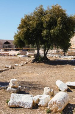 Resimli güneşli manzara Kizkalesi kalesinin iç bahçesindeki antik kalıntıları gösteriyor. Ön plandaki sütunların kalıntıları. Arka planda savunma duvarı var. Ünlü turistik mekan ve romantik mekan.
