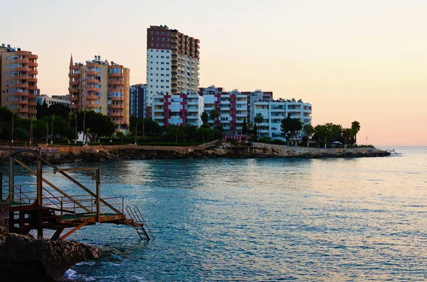 Tipik küçük Türk kasabasının resimli sabah manzarası. Türkiye 'nin Mersin kenti yakınlarındaki Akdeniz kıyısındaki yerleşim yeri. Binalar arasındaki caminin yüksek minaresi.
